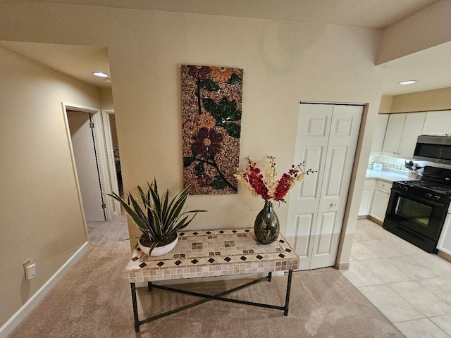 corridor with light tile patterned flooring, baseboards, and light carpet