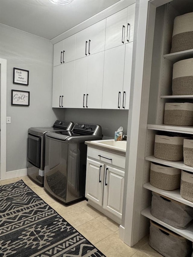 laundry area with light tile patterned floors, baseboards, cabinet space, and independent washer and dryer