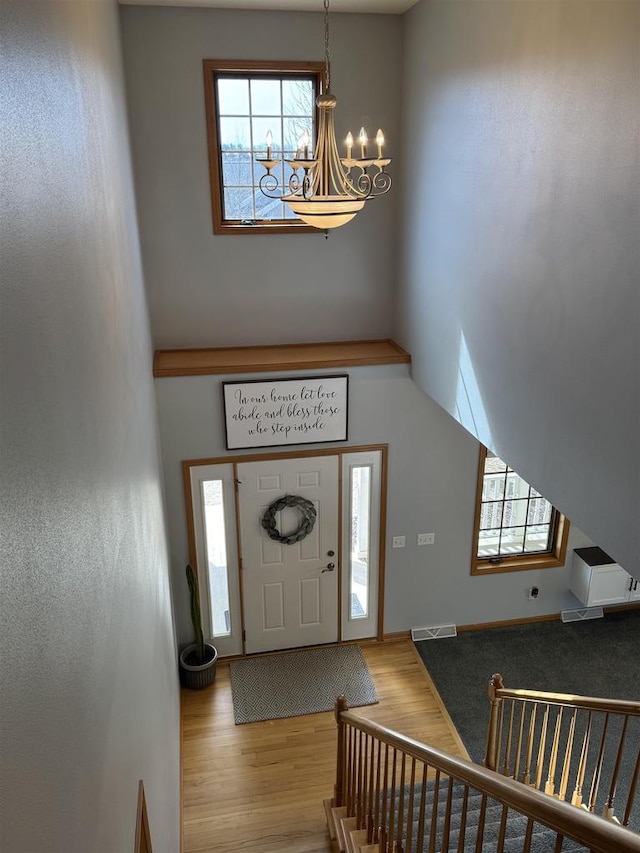 foyer featuring visible vents, a notable chandelier, and wood finished floors