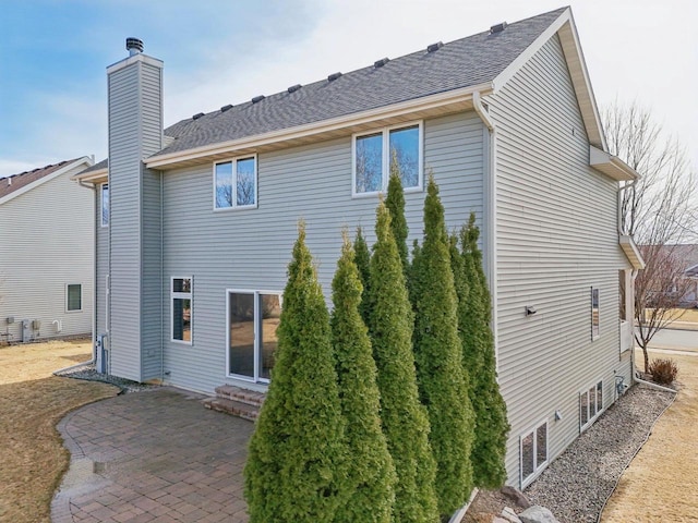 rear view of property with a patio area and a chimney