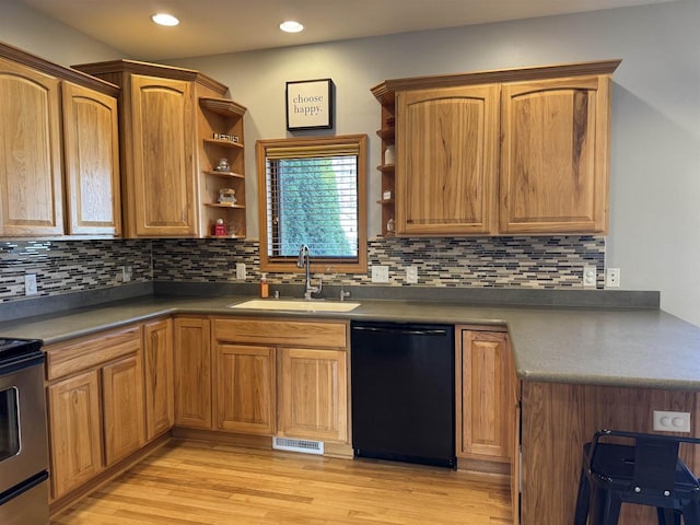 kitchen featuring open shelves, light wood finished floors, black dishwasher, and a sink