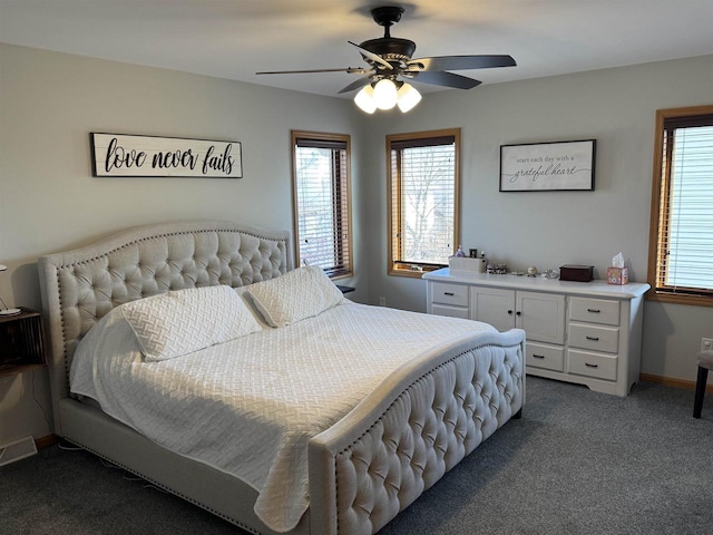 carpeted bedroom featuring baseboards, multiple windows, visible vents, and ceiling fan