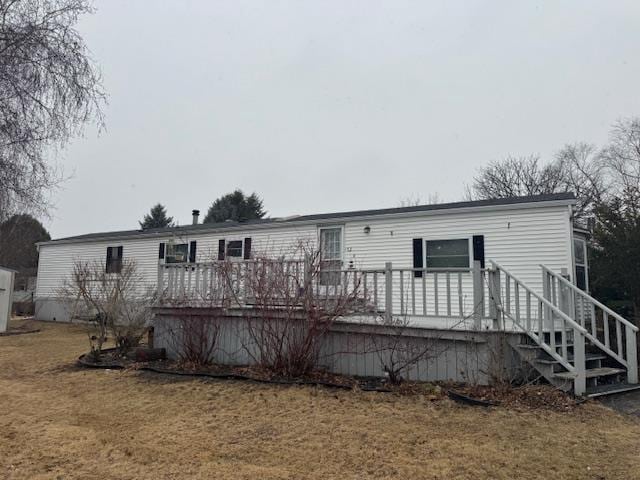 rear view of property featuring a yard and a wooden deck