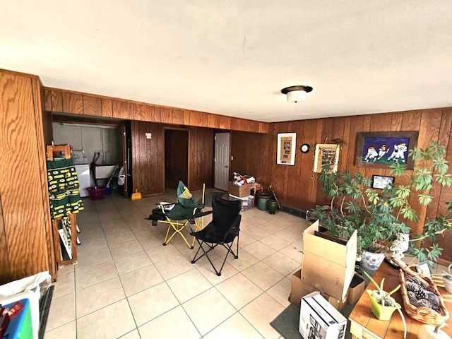 dining space with wood walls and light tile patterned floors