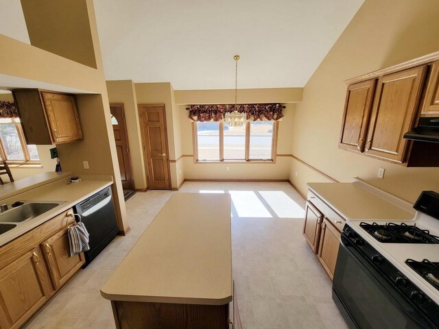 kitchen with black dishwasher, range with gas stovetop, brown cabinets, light countertops, and under cabinet range hood