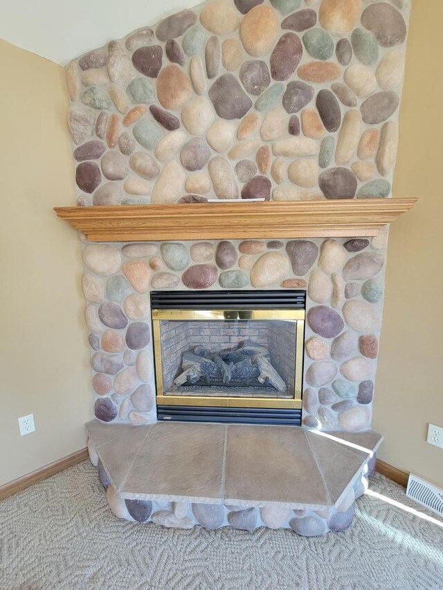 interior details with carpet, a fireplace, visible vents, and baseboards