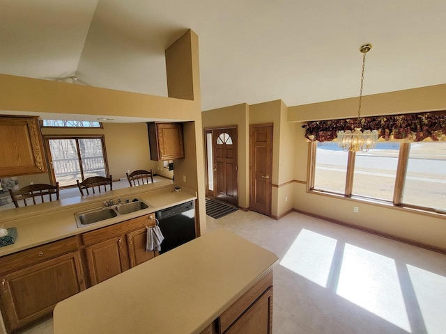 kitchen featuring a wealth of natural light, brown cabinets, dishwasher, and a sink