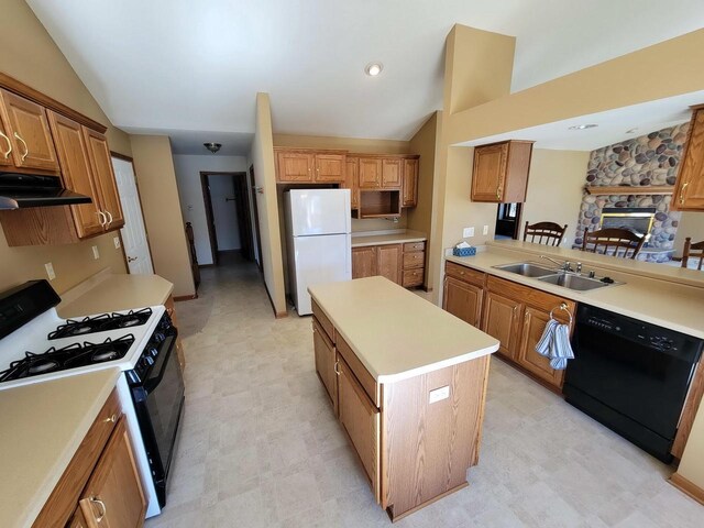 kitchen featuring light floors, under cabinet range hood, a sink, vaulted ceiling, and black appliances