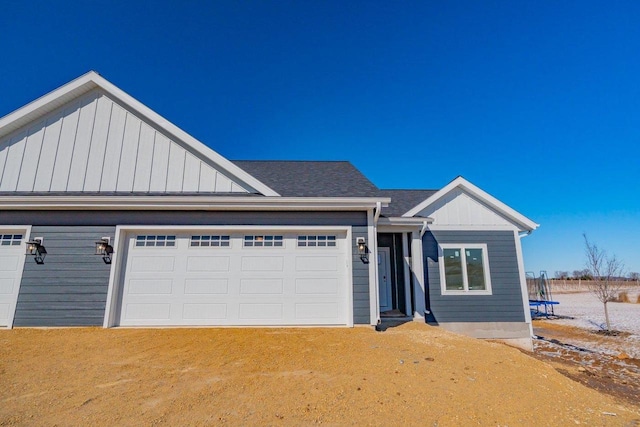 view of front facade featuring board and batten siding, a shingled roof, and driveway