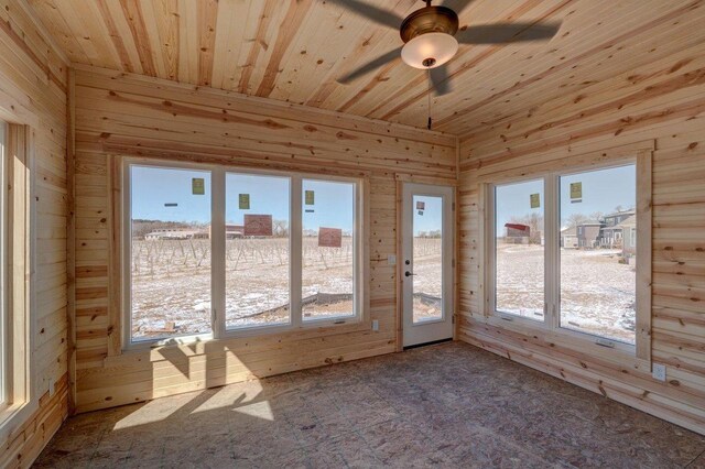 unfurnished sunroom featuring wood ceiling and a ceiling fan