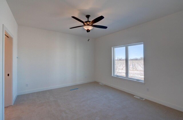 empty room with visible vents, light carpet, and baseboards