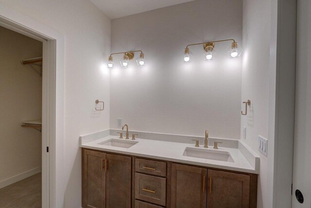 full bath featuring a sink, a spacious closet, and double vanity