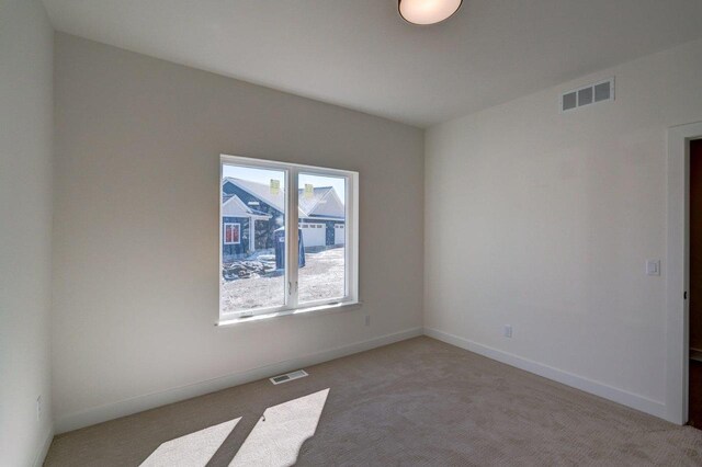 unfurnished room with light carpet, baseboards, and visible vents