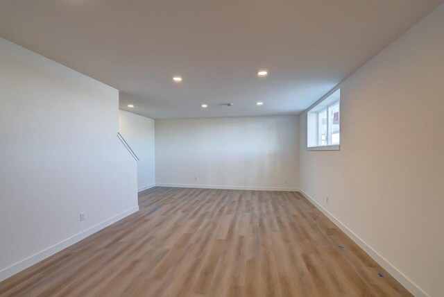 spare room featuring light wood-style flooring, baseboards, and recessed lighting