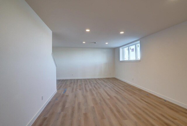 empty room featuring light wood-style floors, recessed lighting, and baseboards