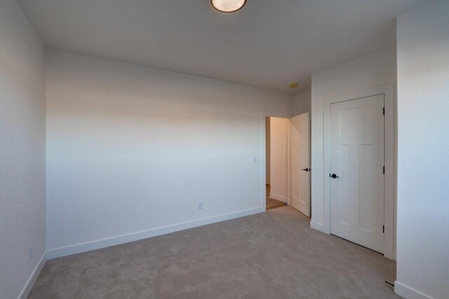 unfurnished bedroom with carpet floors, a closet, and baseboards