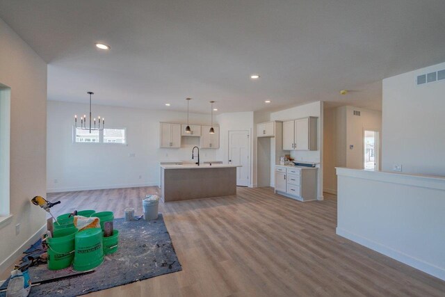 kitchen with a kitchen island with sink, light wood-style flooring, visible vents, and recessed lighting