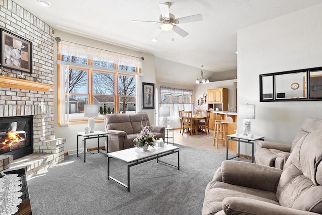 living area with a ceiling fan, vaulted ceiling, a fireplace, and baseboards