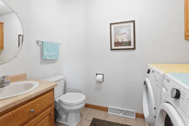 bathroom featuring visible vents, baseboards, toilet, independent washer and dryer, and tile patterned flooring