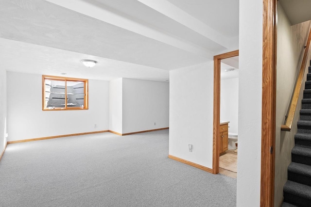 finished basement with stairs, carpet flooring, and baseboards