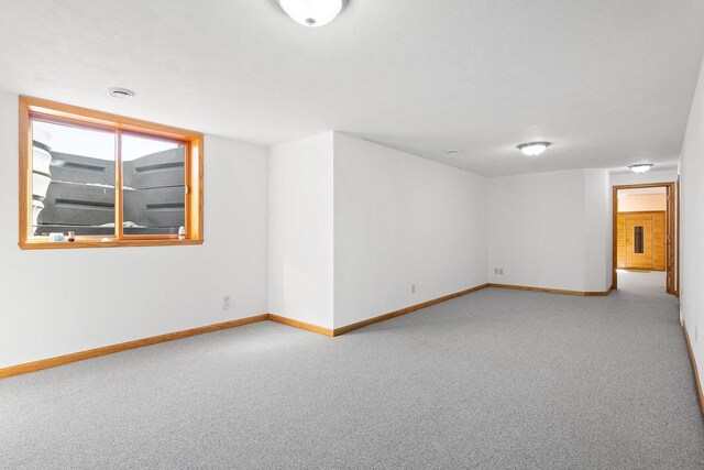 unfurnished room featuring carpet and baseboards