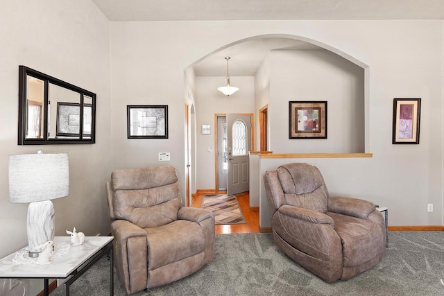 interior space featuring arched walkways, carpet flooring, and baseboards