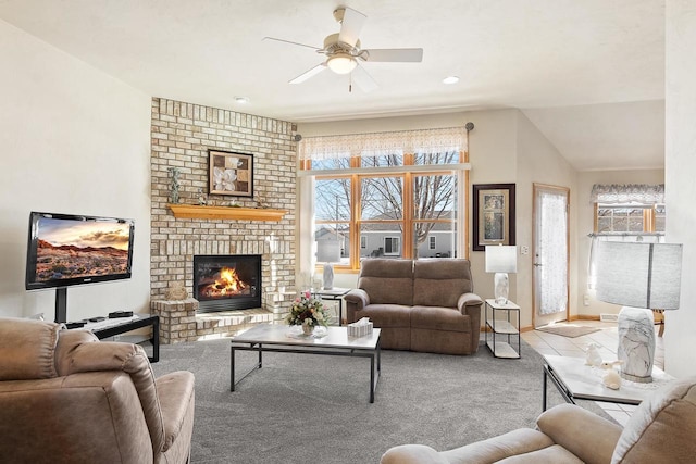 living area with a fireplace, carpet flooring, a wealth of natural light, and a ceiling fan