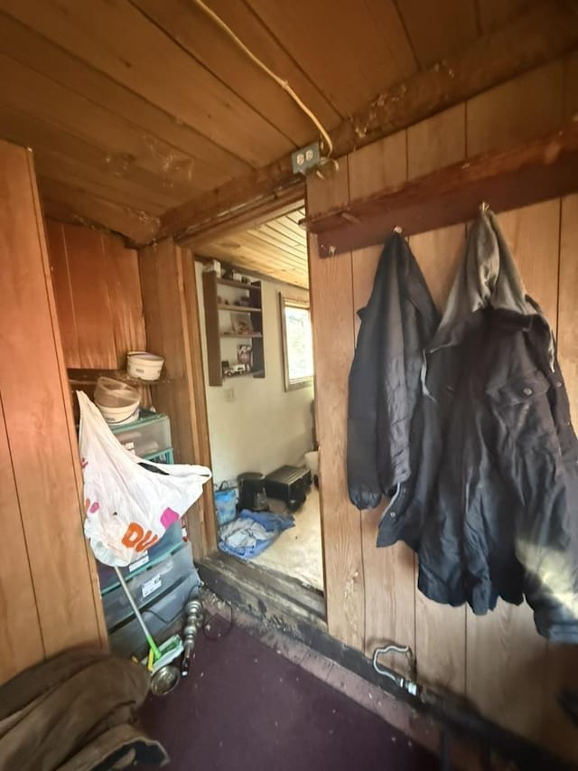 mudroom featuring wooden ceiling and wood walls