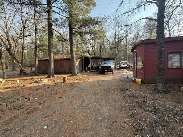 view of side of home with dirt driveway