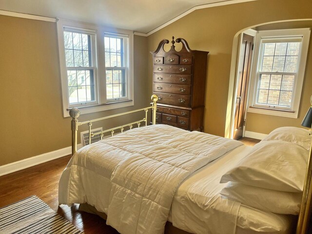 bedroom with vaulted ceiling, multiple windows, wood finished floors, and baseboards