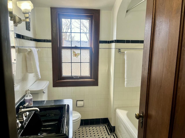 bathroom with toilet, tile walls, and tile patterned flooring