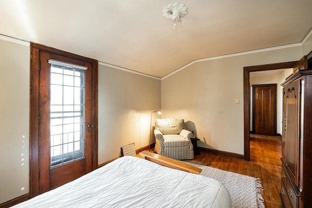 bedroom featuring multiple windows, ornamental molding, wood finished floors, baseboards, and vaulted ceiling