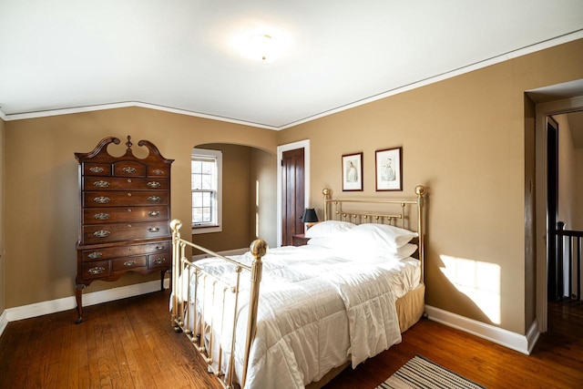 bedroom featuring arched walkways, ornamental molding, baseboards, and hardwood / wood-style floors