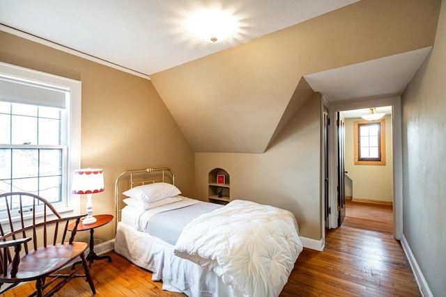 bedroom featuring vaulted ceiling, wood finished floors, and baseboards