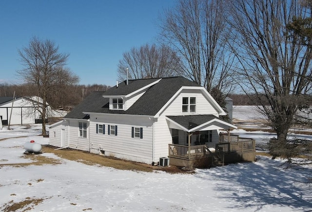 exterior space with central air condition unit and roof with shingles