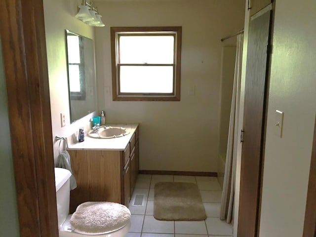 bathroom with vanity, shower / bathtub combination with curtain, baseboards, tile patterned floors, and toilet