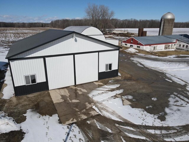 snow covered structure with an outbuilding and an outdoor structure