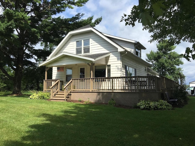 bungalow-style home with a wooden deck and a front lawn