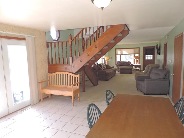 dining area featuring tile patterned floors, plenty of natural light, wallpapered walls, and stairs