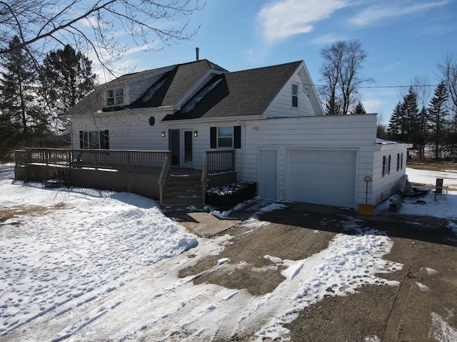 view of front of home with an attached garage, a wooden deck, and roof with shingles