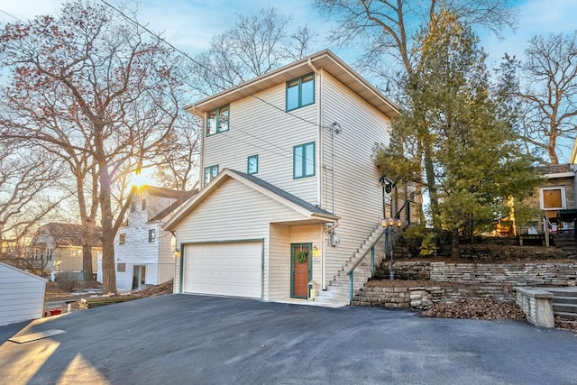 view of home's exterior featuring driveway, a garage, and stairway