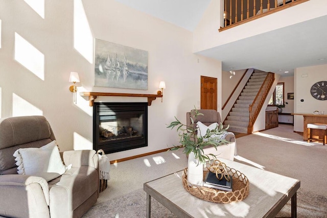 living room with baseboards, stairs, a high ceiling, carpet flooring, and a multi sided fireplace