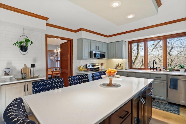 kitchen featuring backsplash, appliances with stainless steel finishes, gray cabinets, and light countertops