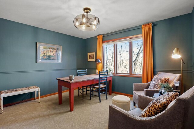 carpeted office space featuring an inviting chandelier and baseboards