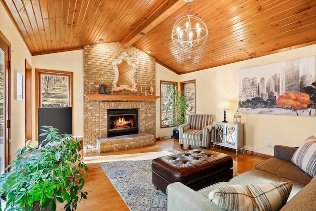 living room featuring lofted ceiling with beams, wooden ceiling, a fireplace, wood finished floors, and an inviting chandelier