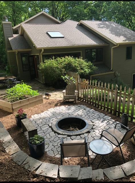 view of patio featuring an outdoor fire pit, fence, and a garden