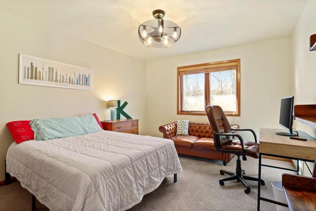 bedroom featuring carpet flooring and an inviting chandelier