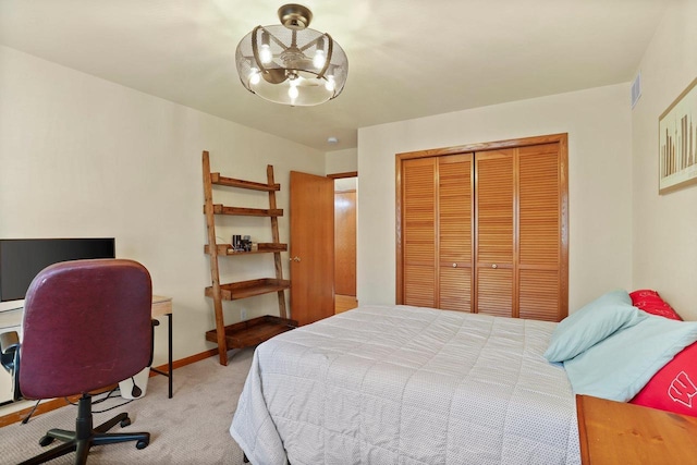 bedroom with baseboards, visible vents, an inviting chandelier, carpet floors, and a closet