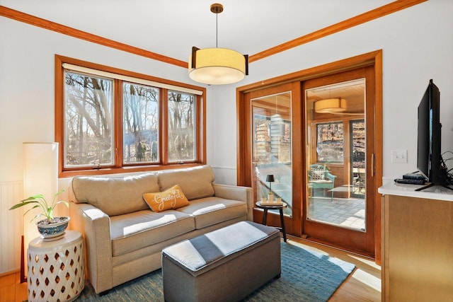 living area featuring ornamental molding and wood finished floors