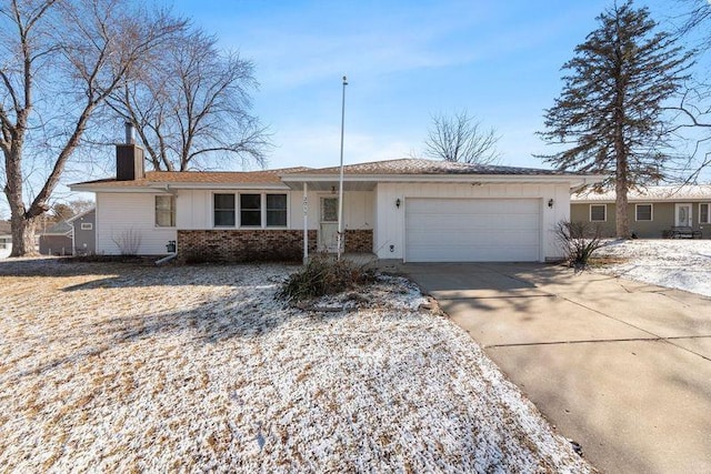 single story home with a garage, concrete driveway, brick siding, and a chimney